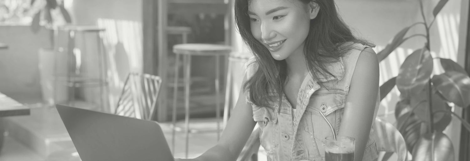 Woman at a laptop signing up online for a free, live TEFL certification information session