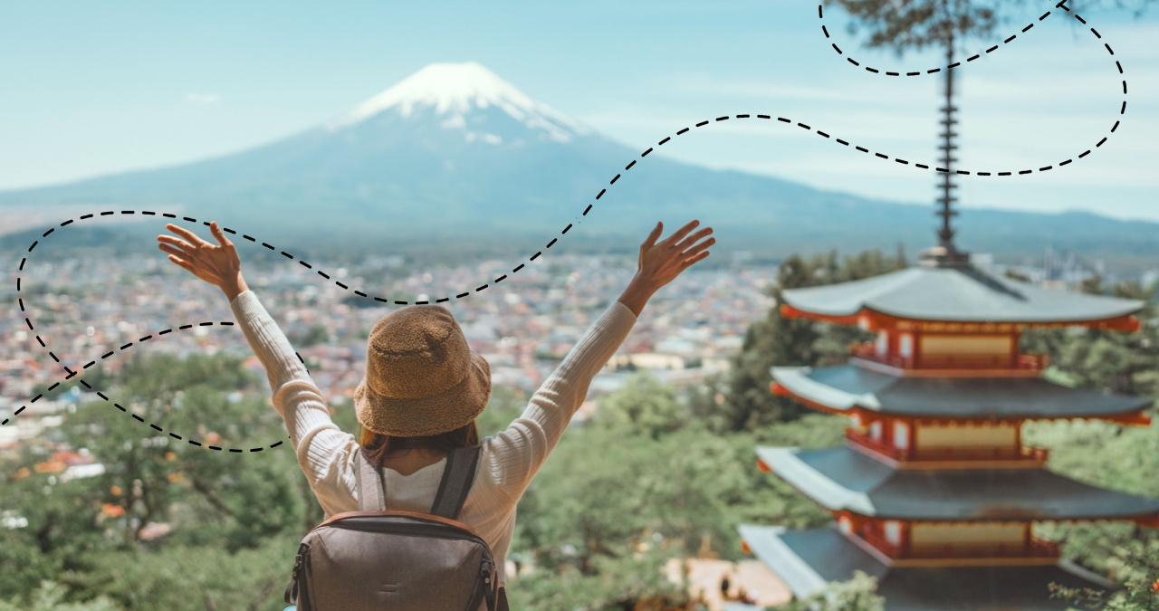 tefl teacher grad with outstretched arms overlooking Mount Fuji and a traditional Japanese pagoda.